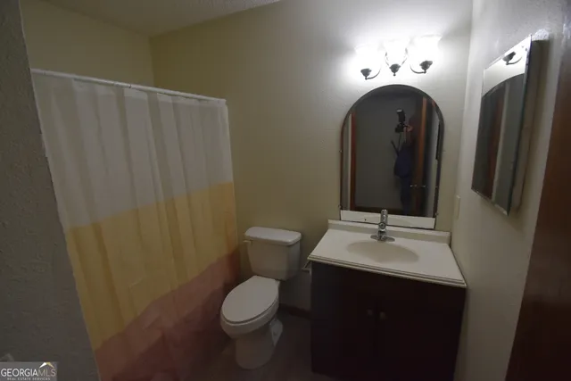 a bathroom with a toilet sink and mirror