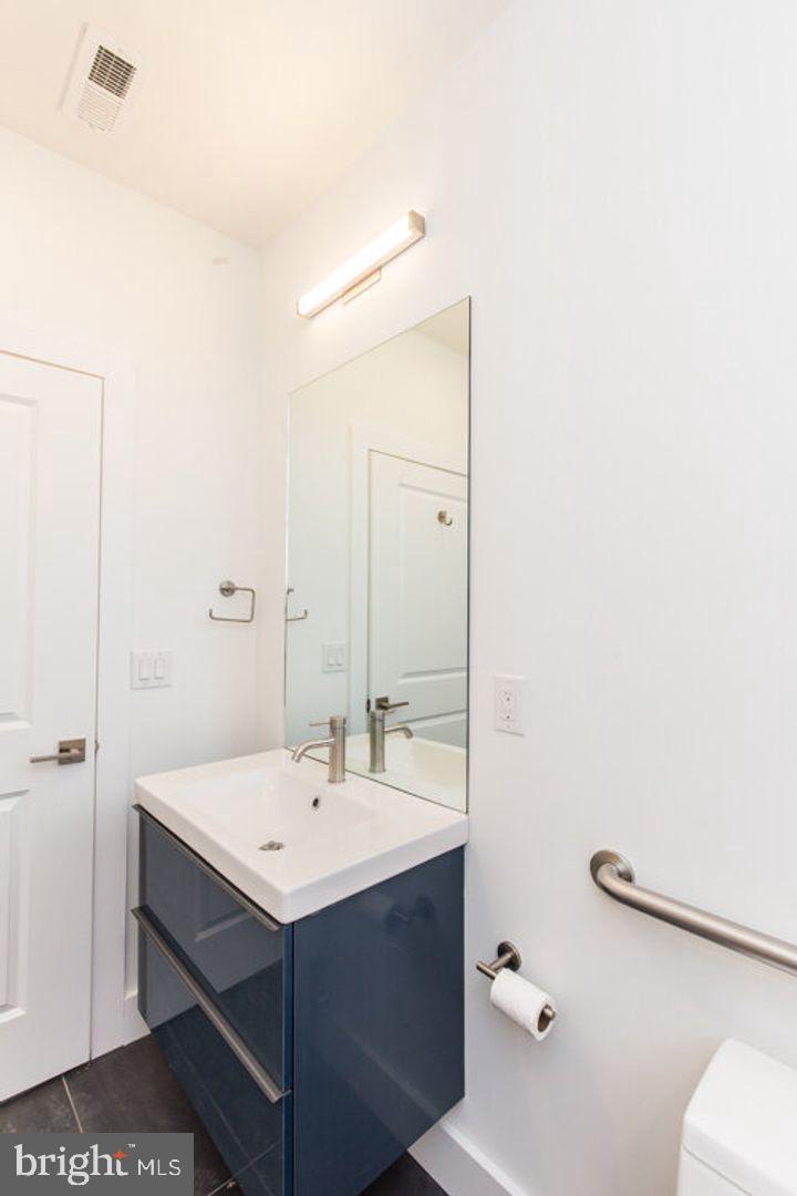 4100 Ludlow Street, Unit 1S Philadelphia, PA 19104 - Photo 11 of 16 a bathroom with a sink mirror and a toilet