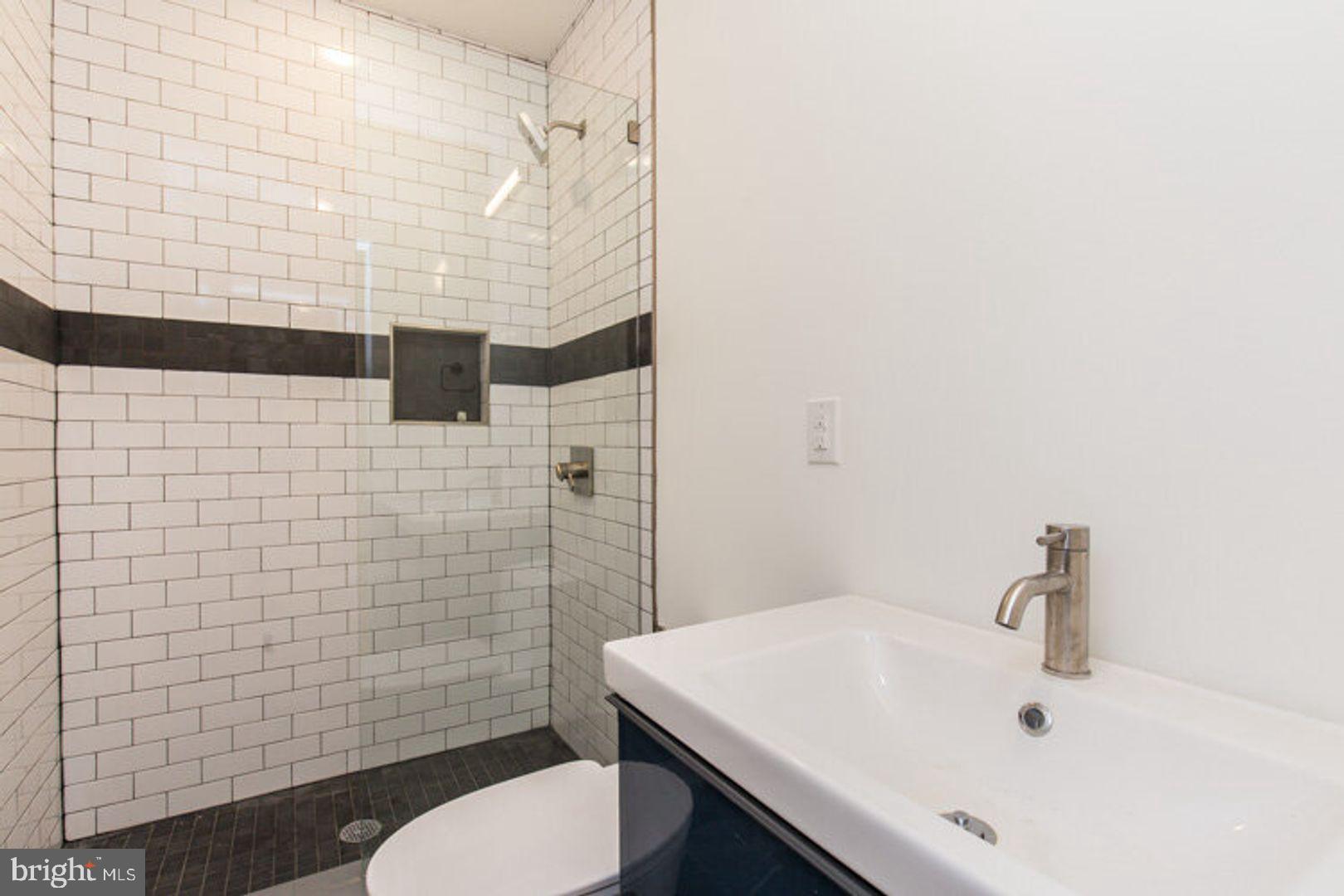 4100 Ludlow Street, Unit 1S Philadelphia, PA 19104 - Photo 14 of 16 a bathroom with a sink a toilet and shower