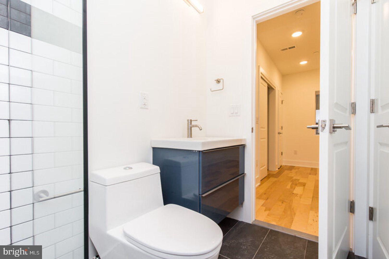 4100 Ludlow Street, Unit 1S Philadelphia, PA 19104 - Photo 15 of 16 a bathroom with a toilet sink vanity and shower