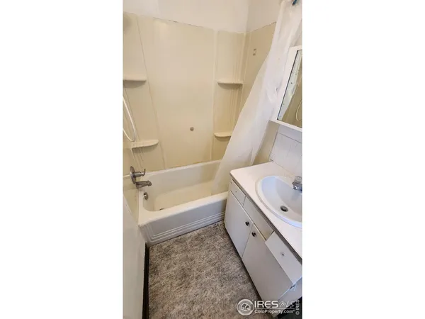 a bathroom with a tub sink and mirror