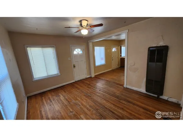 a room with wooden floor and windows