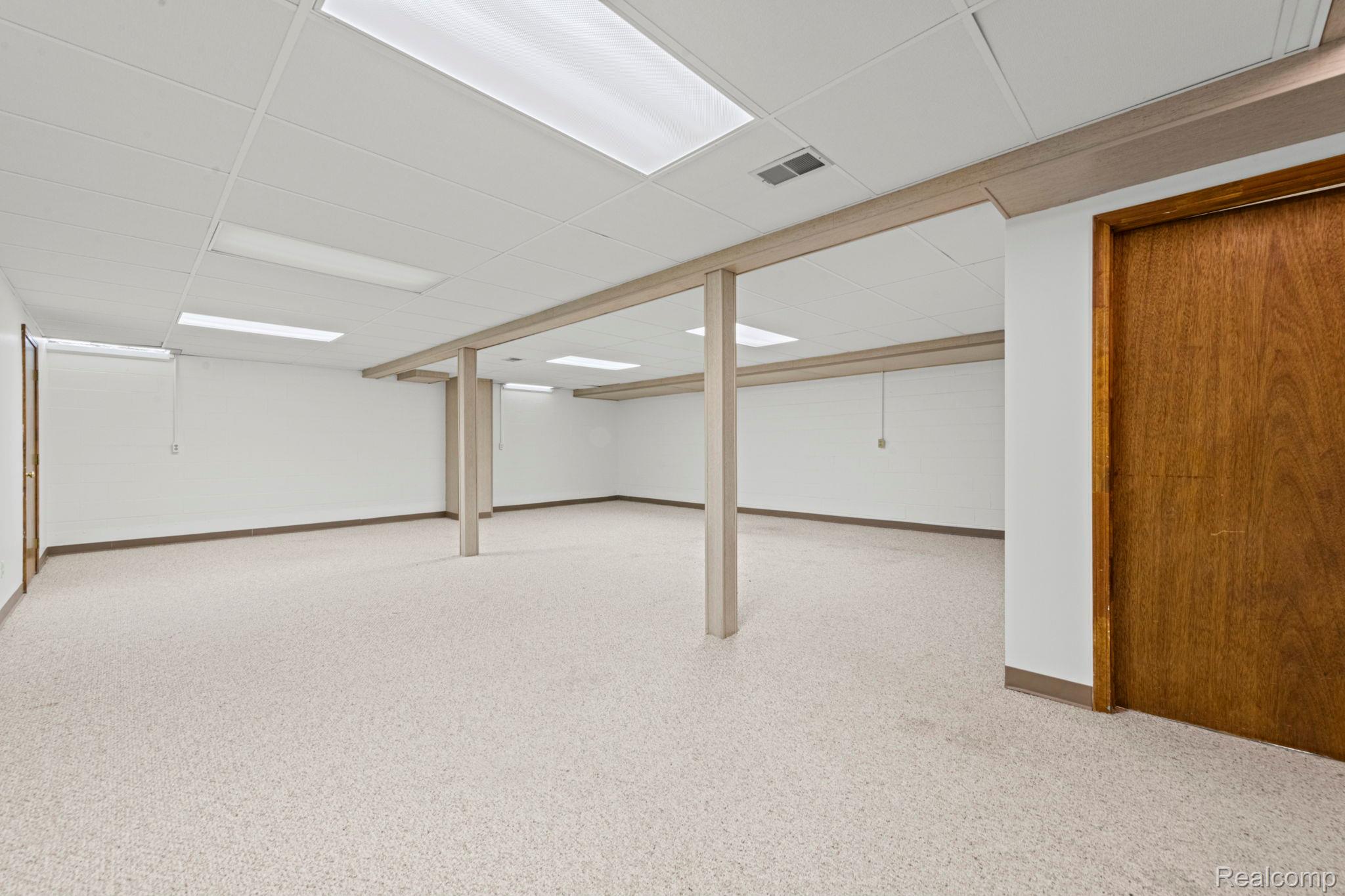 21580 Georgetown Road Trenton, MI 48183 - Photo 24 of 36 Expansive room featuring light-toned carpet flooring, white walls, and a drop ceiling with integrated fluorescent lighting