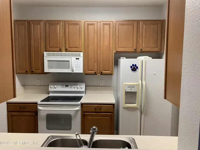 a kitchen with appliances a sink and cabinets
