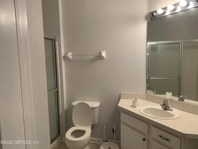a bathroom with a toilet a sink and mirror