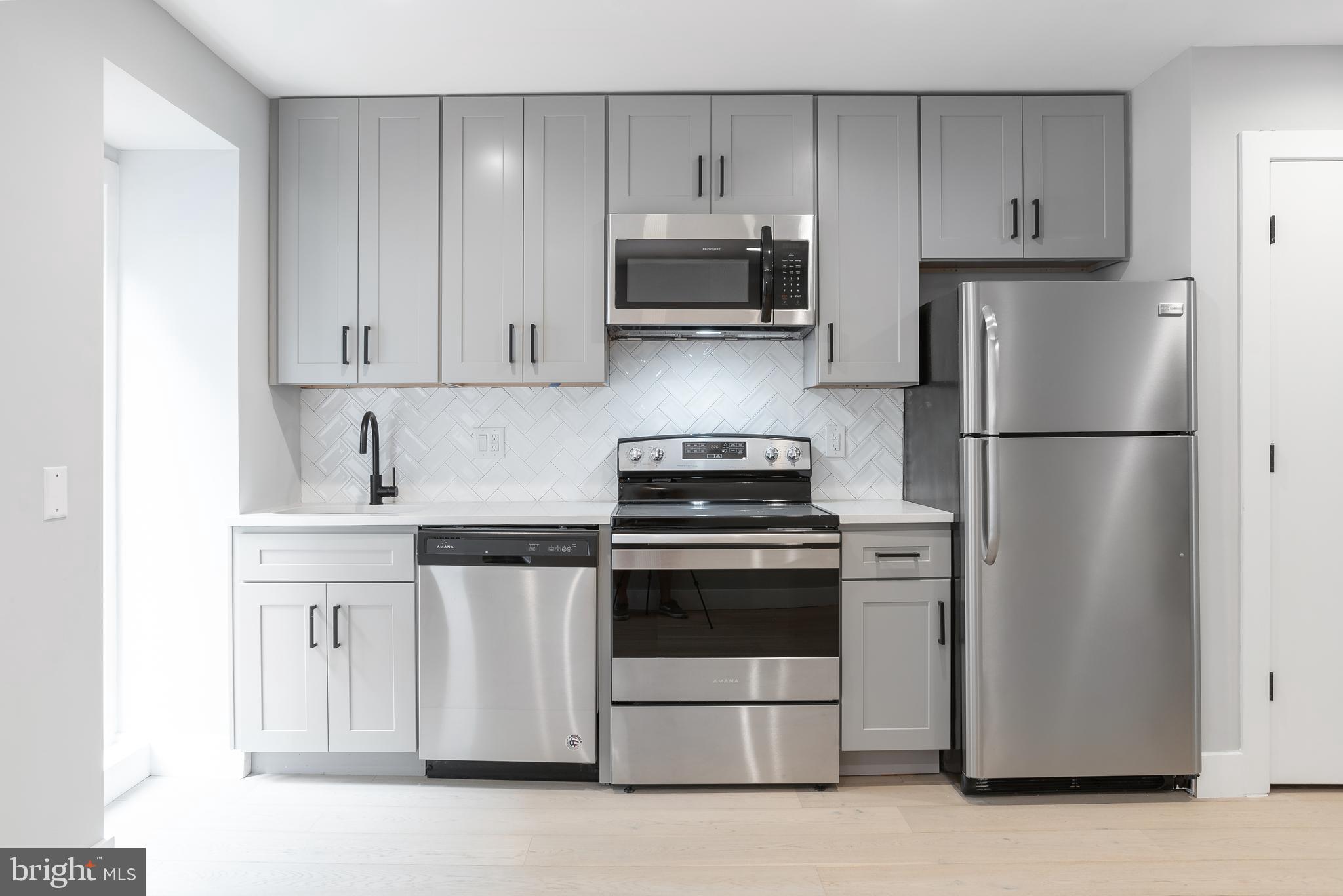 1707 Rittenhouse Square, Unit 3R Philadelphia, PA 19103 - Photo 4 of 13 a kitchen with stainless steel appliances granite countertop a refrigerator stove and microwave