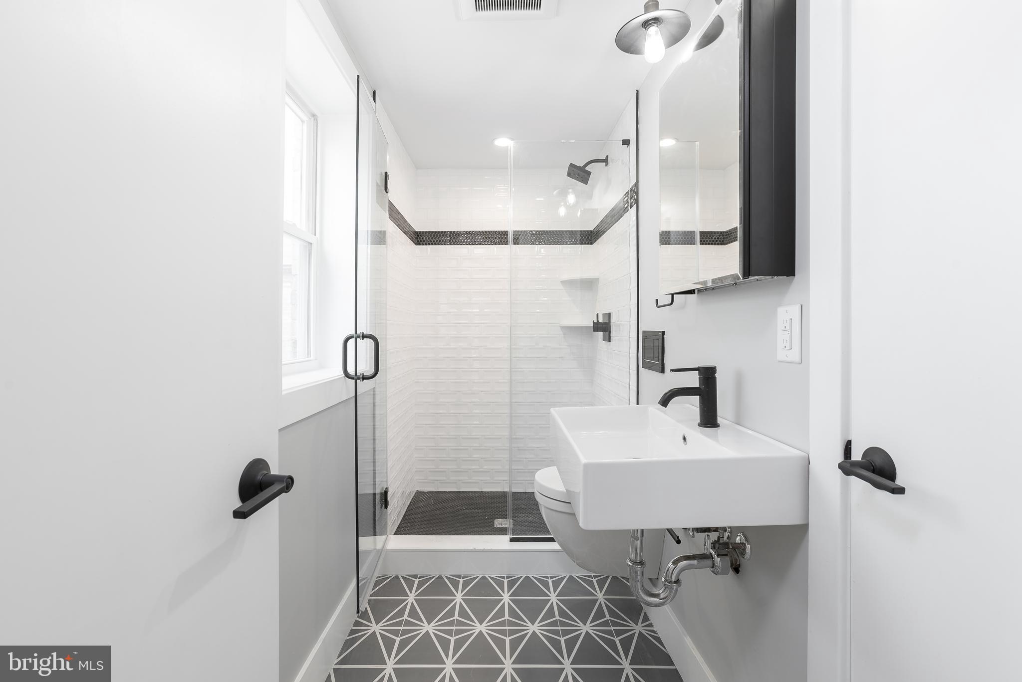 1707 Rittenhouse Square, Unit 3R Philadelphia, PA 19103 - Photo 8 of 13 a bathroom with a sink a toilet a mirror and shower