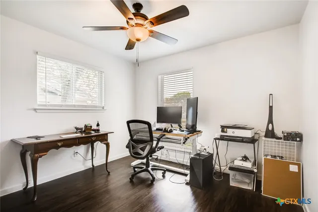 a view of a workspace with furniture and a window