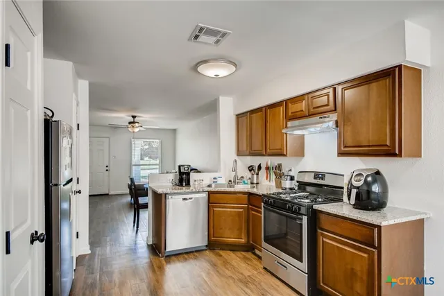 a kitchen with stainless steel appliances a sink stove and refrigerator