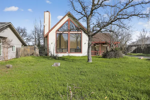 a view of a house with backyard and a tree