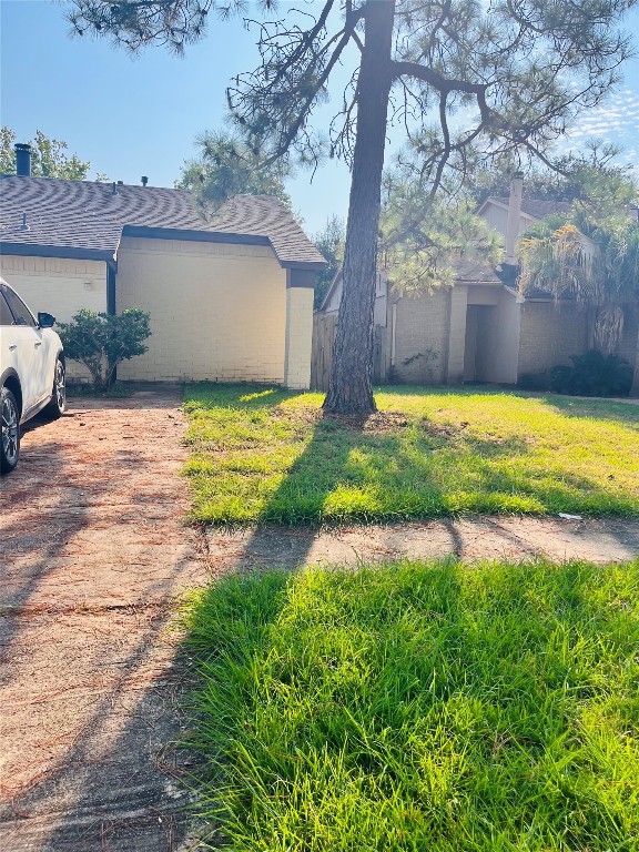 a backyard of a house with a yard and basket ball court