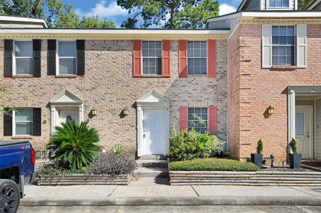 a front view of a house with garage and plants