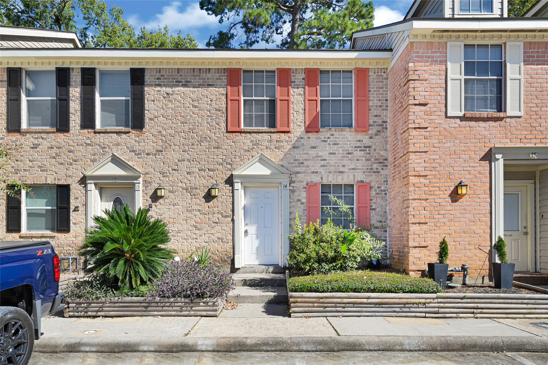 2030 Plantation Drive, Unit B14 Conroe, TX 77301 - Photo 1 of 19 a front view of a house with garage and plants