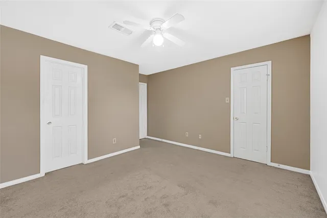 a view of an empty room with a ceiling fan