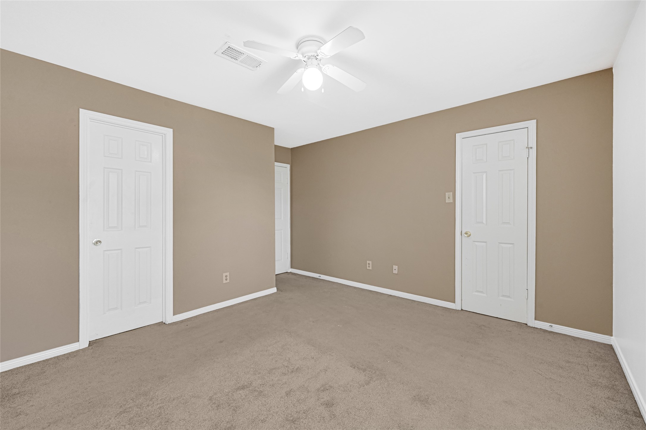 2030 Plantation Drive, Unit B14 Conroe, TX 77301 - Photo 13 of 19 a view of an empty room with a ceiling fan