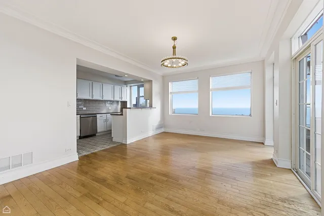 a view of empty room with wooden floor and window