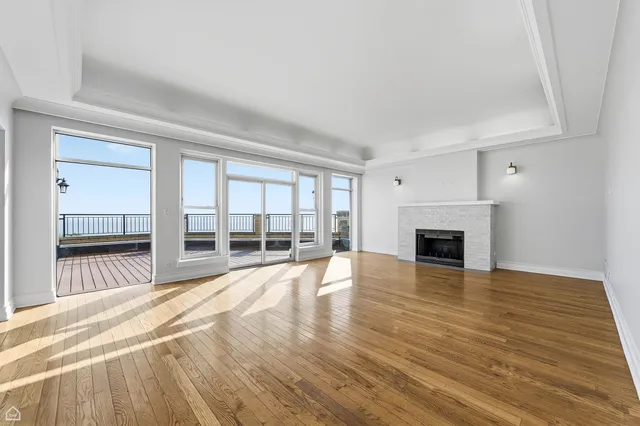 a view of empty room with wooden floor and fireplace