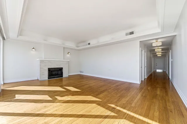 a view of a livingroom with wooden floor and a fireplace