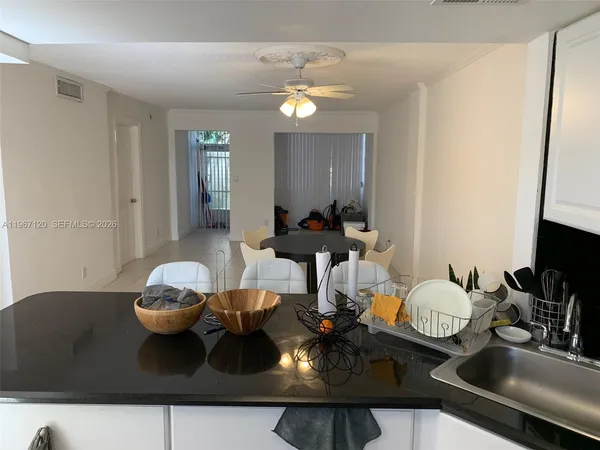 a kitchen with a sink and a stove with wooden floor