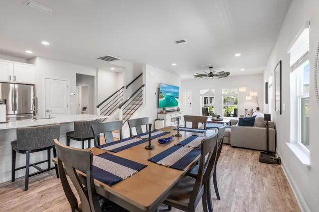a living room with lots of furniture and a dining table with wooden floor
