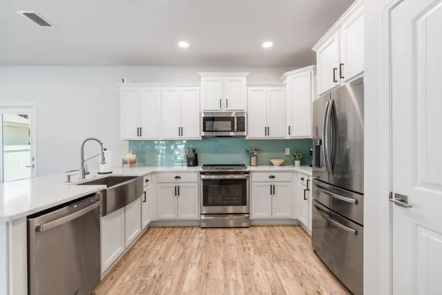 a kitchen with granite countertop a refrigerator stove and sink