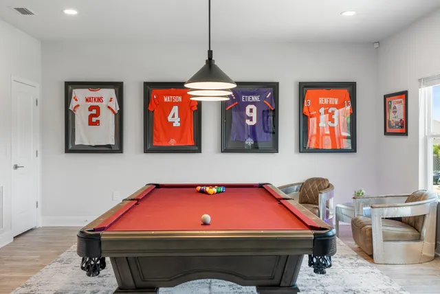 a room with furniture pool table and a flat screen tv