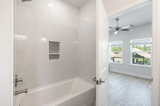 an empty room with a window and a fan