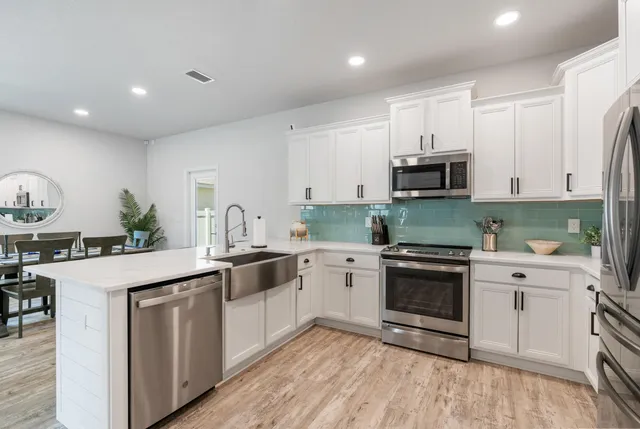 a kitchen with a sink stove and white cabinets