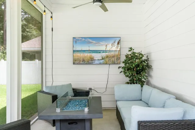 a living room with patio furniture and a potted plant