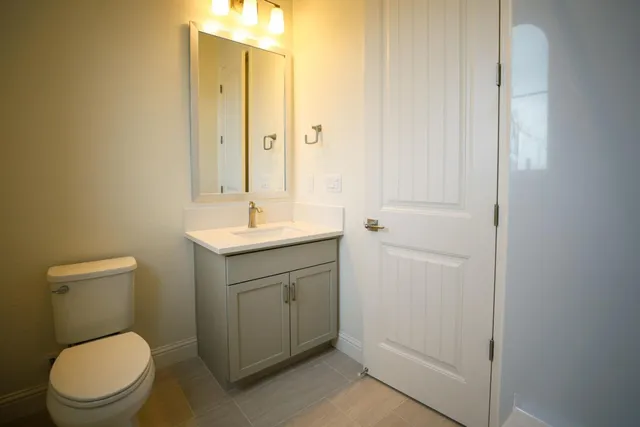 a bathroom with a toilet sink and mirror