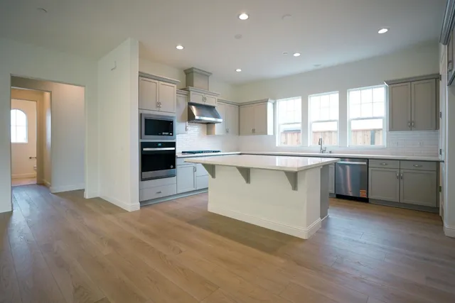 a kitchen with stainless steel appliances granite countertop a white cabinets and sink