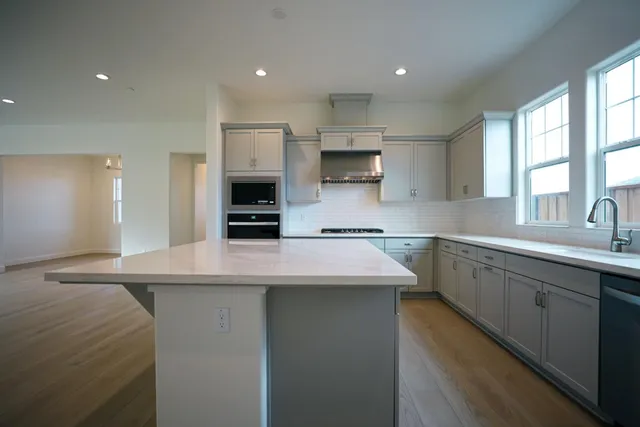 a kitchen with kitchen island white cabinets and refrigerator