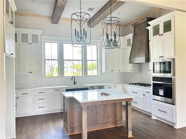 a kitchen with stainless steel appliances a sink a stove and cabinets