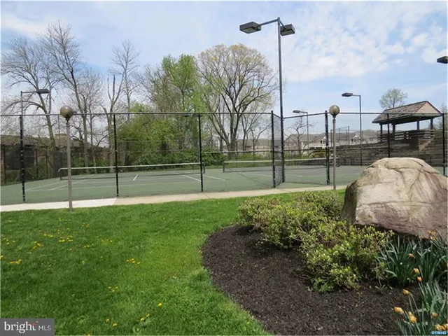 a view of a patio with table and chairs under an umbrella with a small yard