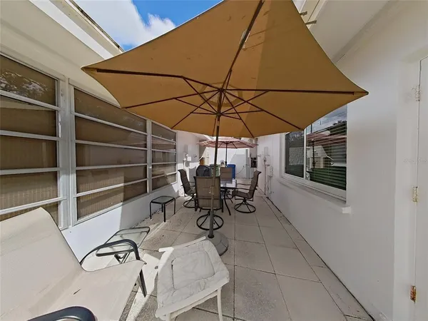 a view of patio with table and chairs under an umbrella