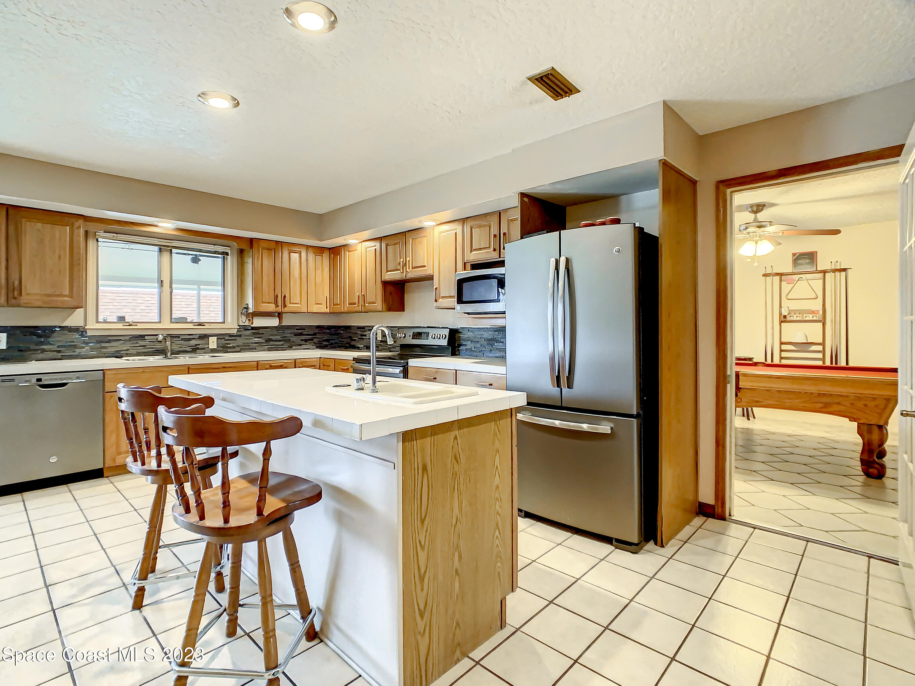1675 East Riviera Drive Merritt Island, FL 32952 - Photo 13 of 50 a kitchen with stainless steel appliances granite countertop a refrigerator and a stove top oven