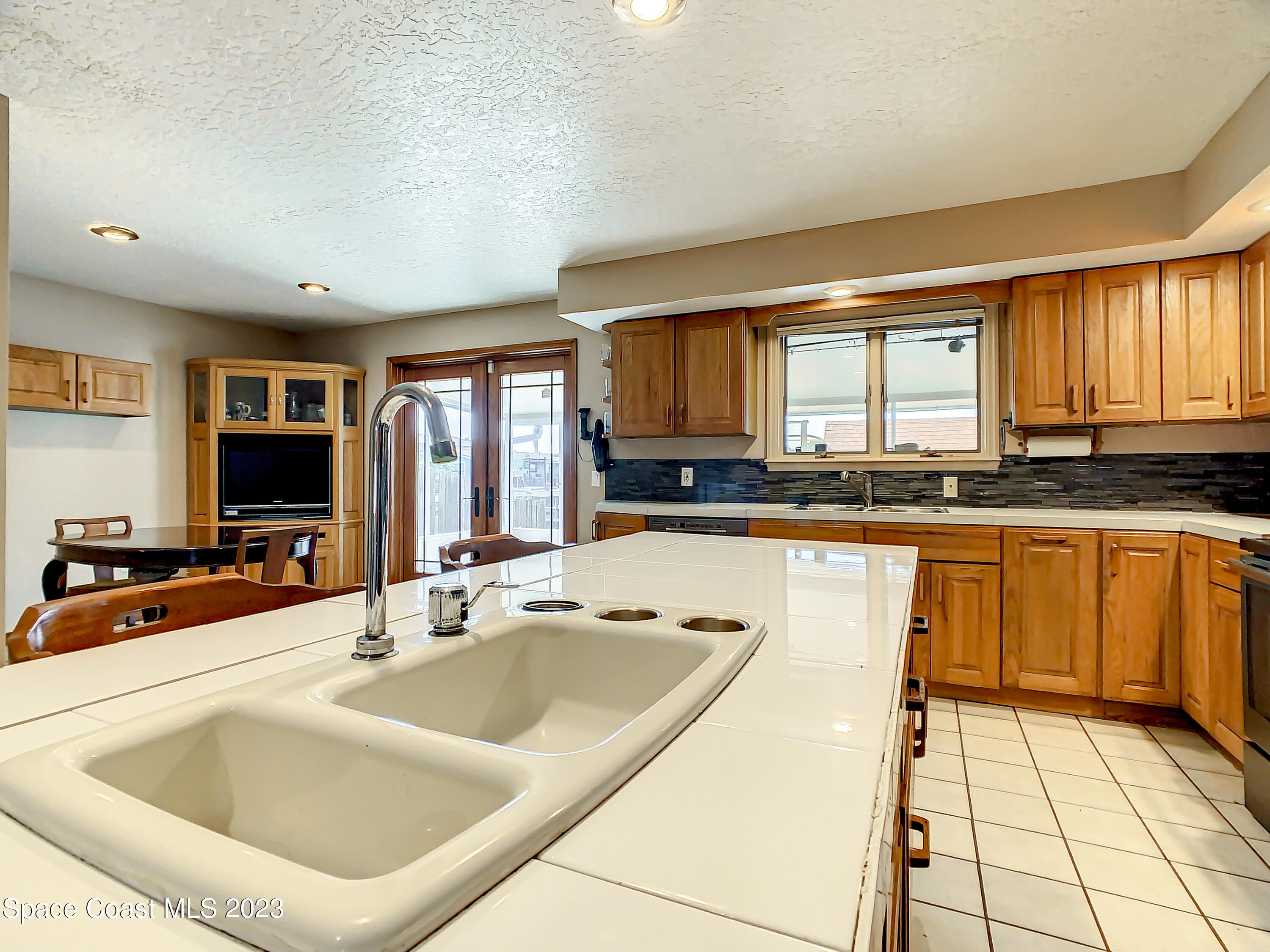 1675 East Riviera Drive Merritt Island, FL 32952 - Photo 15 of 50 a kitchen with a sink window and cabinets
