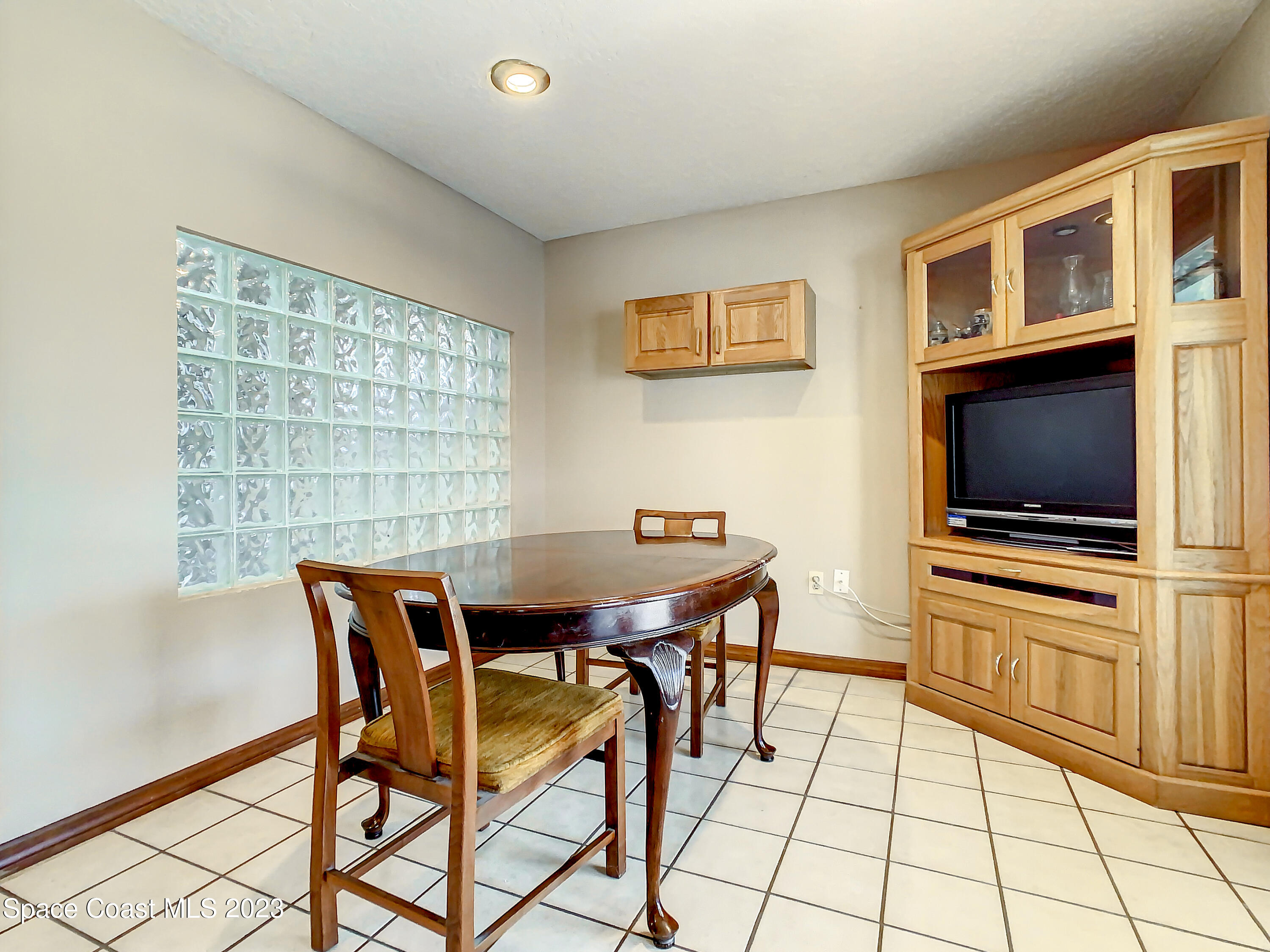 1675 East Riviera Drive Merritt Island, FL 32952 - Photo 18 of 50 a view of a dining room with furniture and a flat screen tv