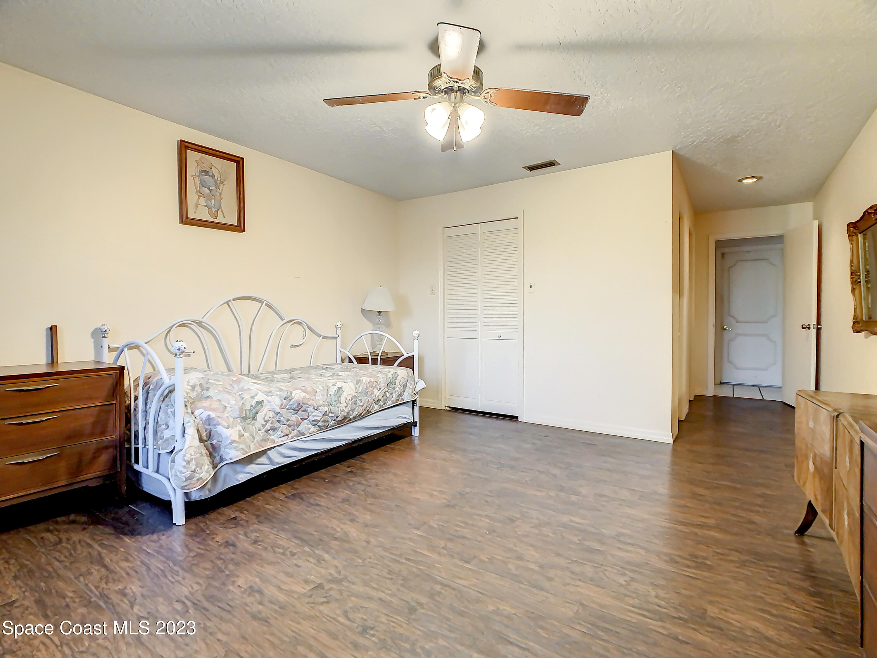 1675 East Riviera Drive Merritt Island, FL 32952 - Photo 20 of 50 a bedroom with a bed and a chandelier