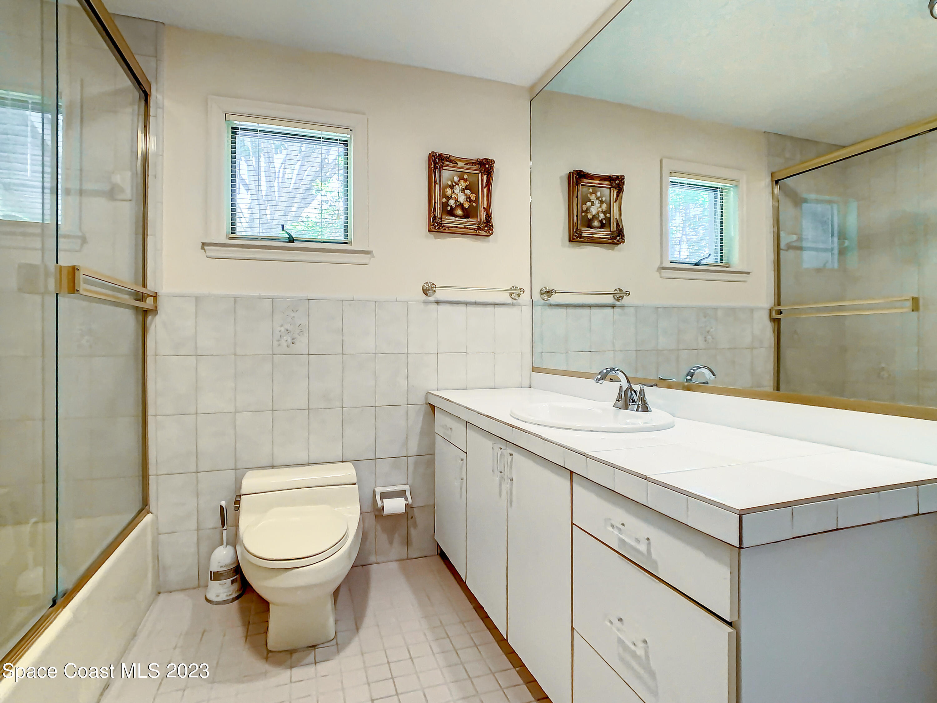 1675 East Riviera Drive Merritt Island, FL 32952 - Photo 22 of 50 a bathroom with a toilet sink and mirror