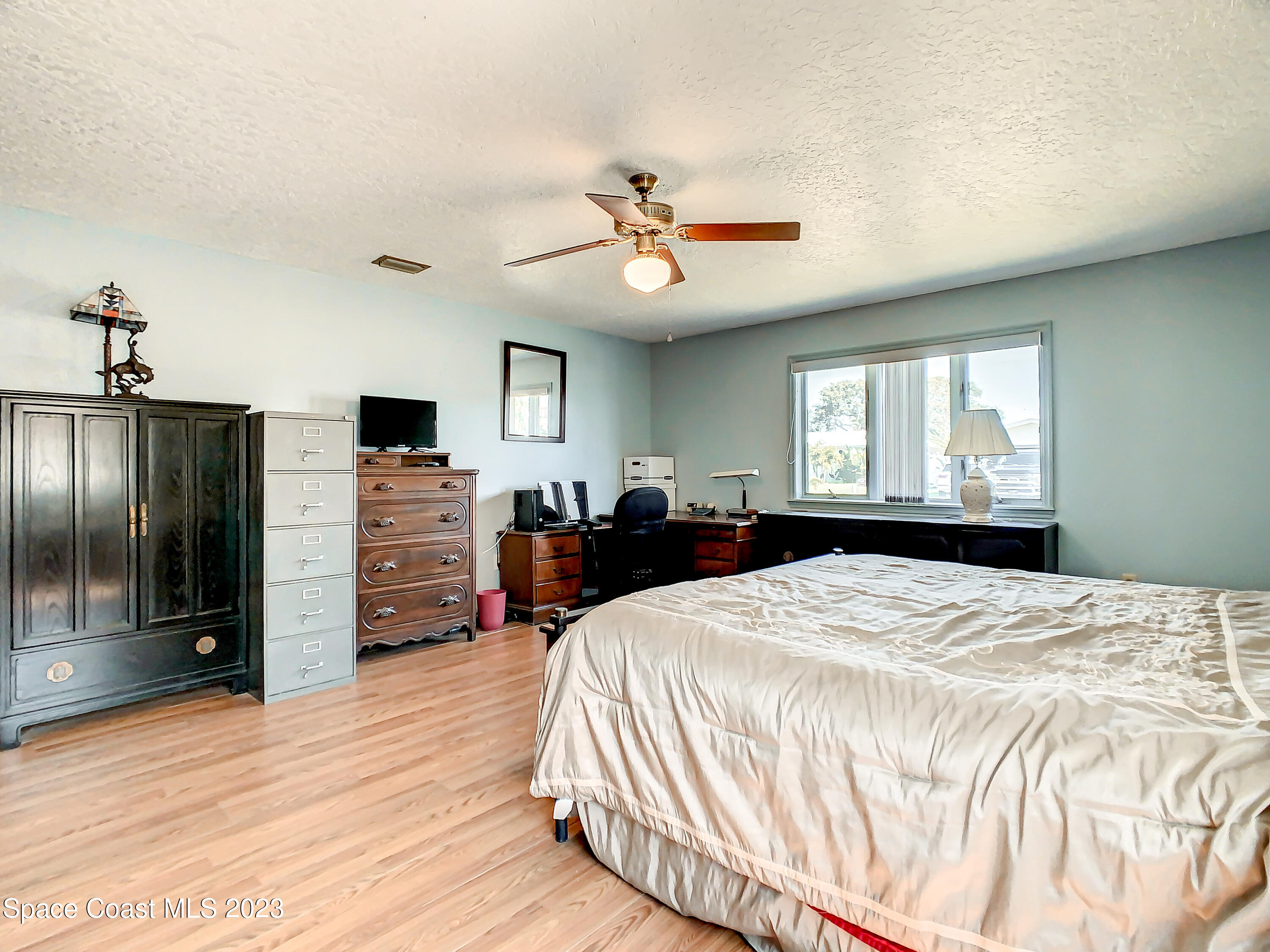 1675 East Riviera Drive Merritt Island, FL 32952 - Photo 27 of 50 a spacious bedroom with a bed and a chandelier