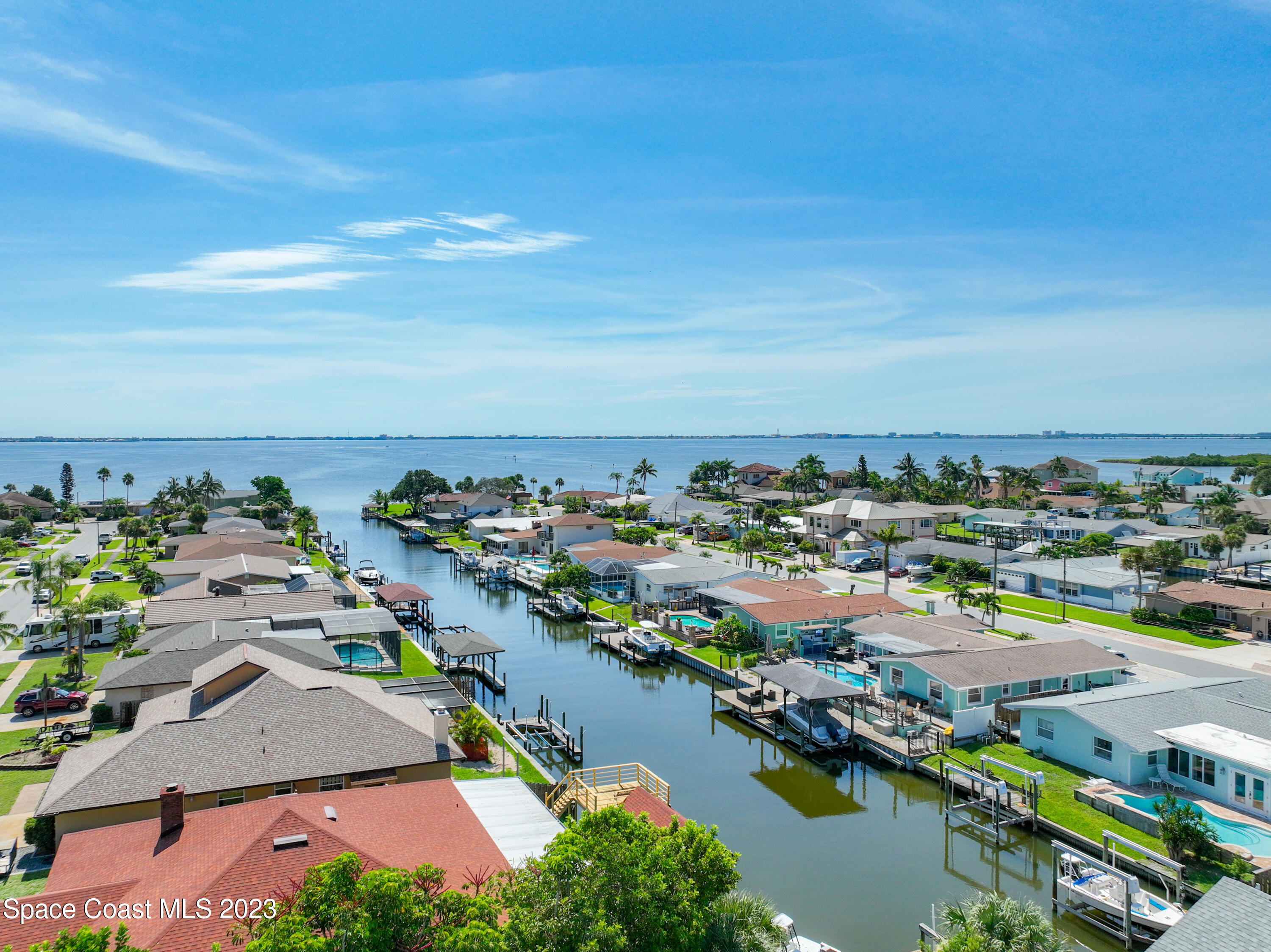 1675 East Riviera Drive Merritt Island, FL 32952 - Photo 47 of 50 an aerial view of a city with lots of residential buildings ocean and mountain view in back