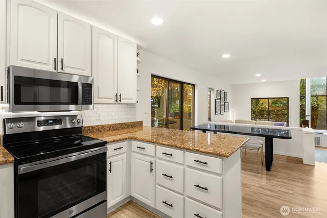 a kitchen with stainless steel appliances granite countertop a stove and a microwave