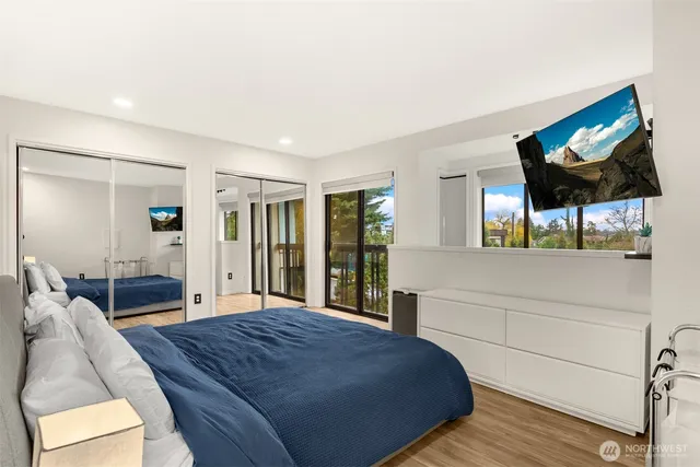 a spacious bedroom with a bed and a flat screen tv