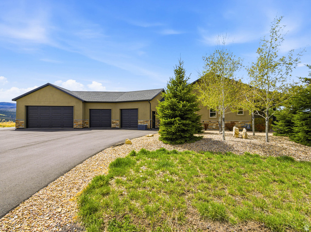 402 Shadow Hill Road Wanship, UT 84017 - Photo 66 of 90 Ranch-style home featuring stone siding, an attached garage, stucco siding, and asphalt driveway