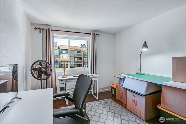 a view of a workspace with furniture and a window