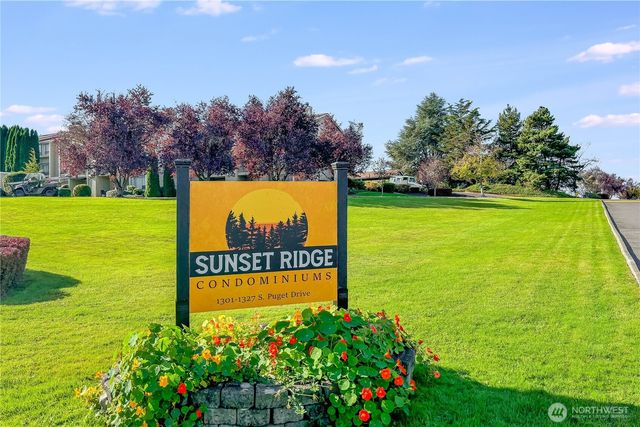 a sign that is sitting in the grass next to a yard