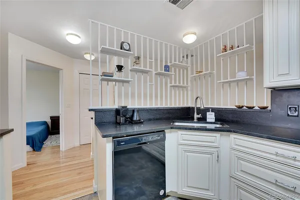 a view of kitchen island a sink wooden floor and living room view