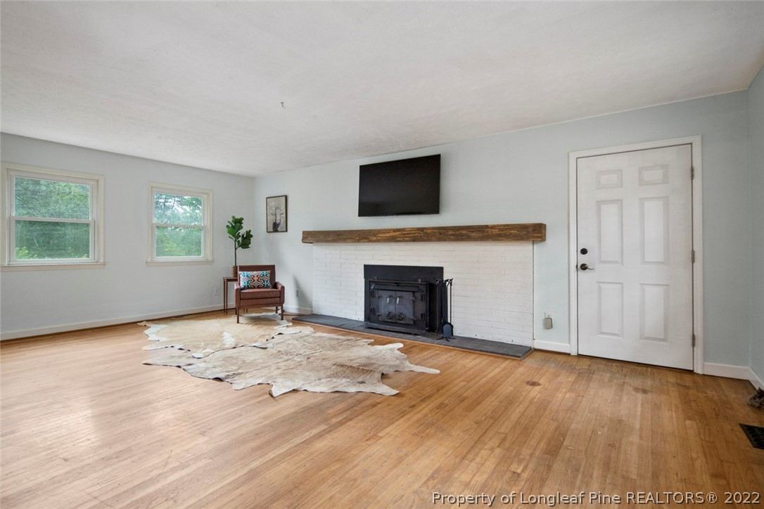 457 Napier Road Carthage, NC 28327 - Photo 8 of 49 an empty room with windows fireplace and wooden floor