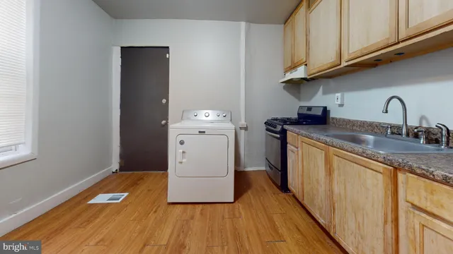 a kitchen with granite countertop a sink a stove and cabinets